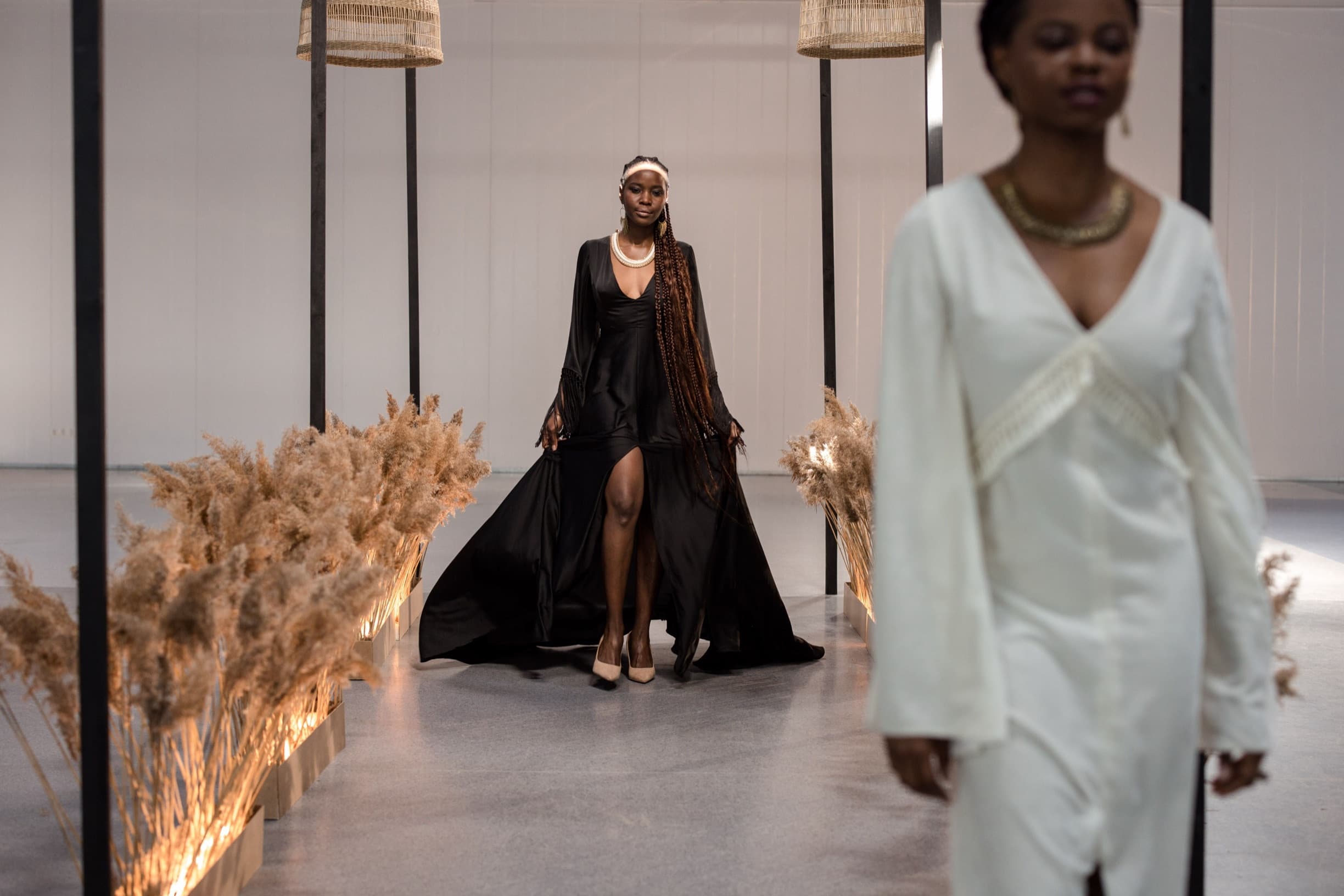 Défilé de mode : un mannequin en robe noire sur le podium